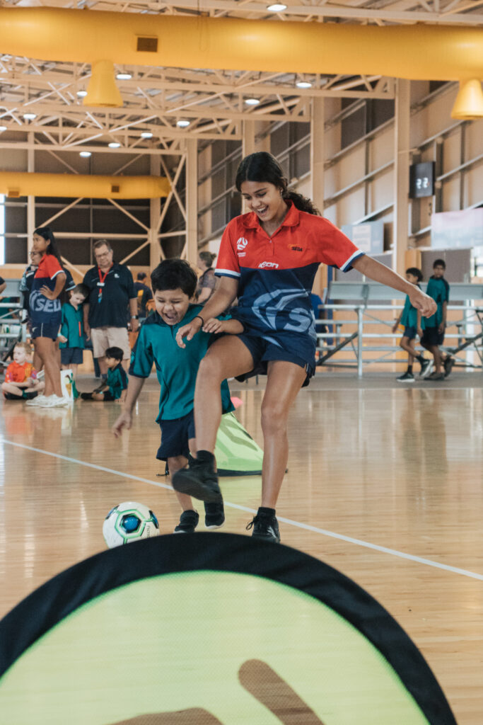 younger boy and older girl playing soccer