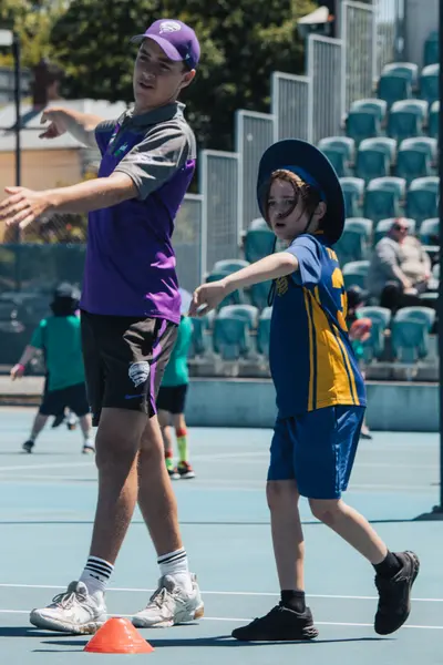 Adult showing child how to throw a ball