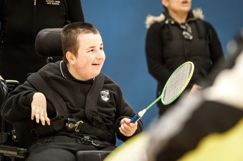 Boy in a wheelchair holding a badminton racket