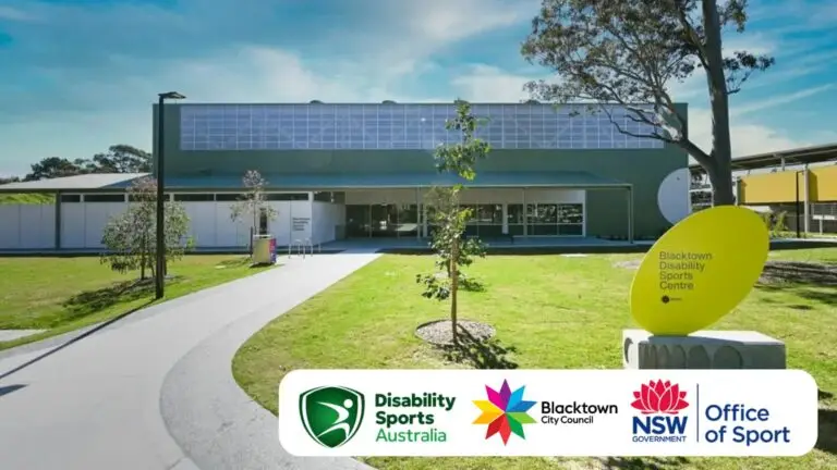 “Blacktown Disability Sports Centre in Western Sydney, featuring a modern green sports building with accessible pathways, trees, and a bright yellow entry sign. Supported by Disability Sports Australia, Blacktown City Council, NSW Government, and Office of Sport.