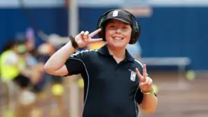 Child wearing headphones smiling and making peace sign during sport program
